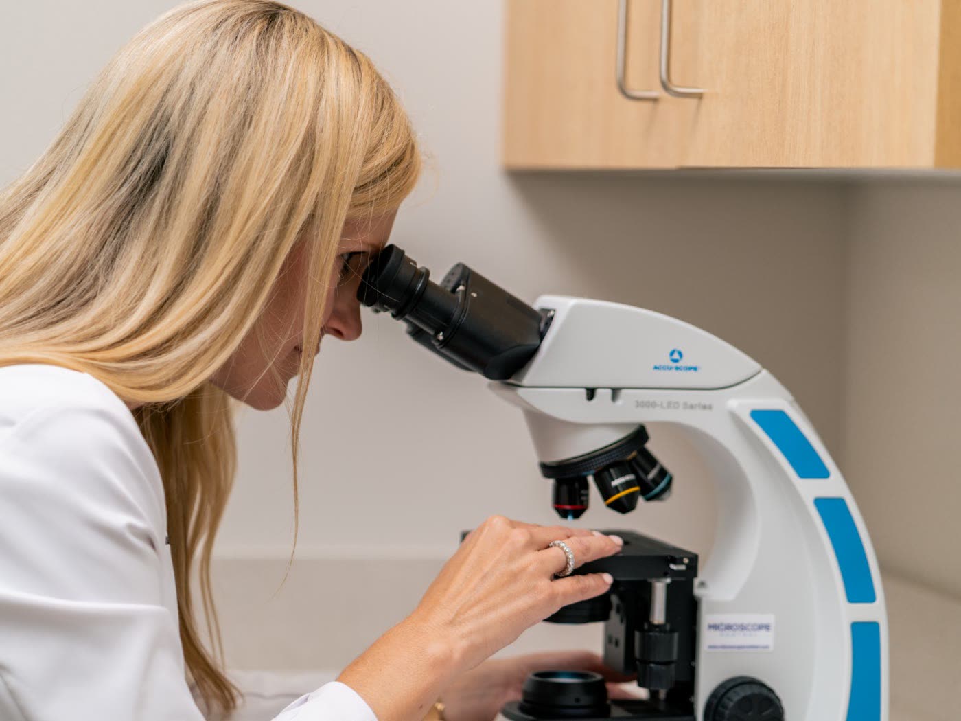 Dr. Sarah Wilson reading Mohs slides under the microscope at Peachtree City Dermatology
